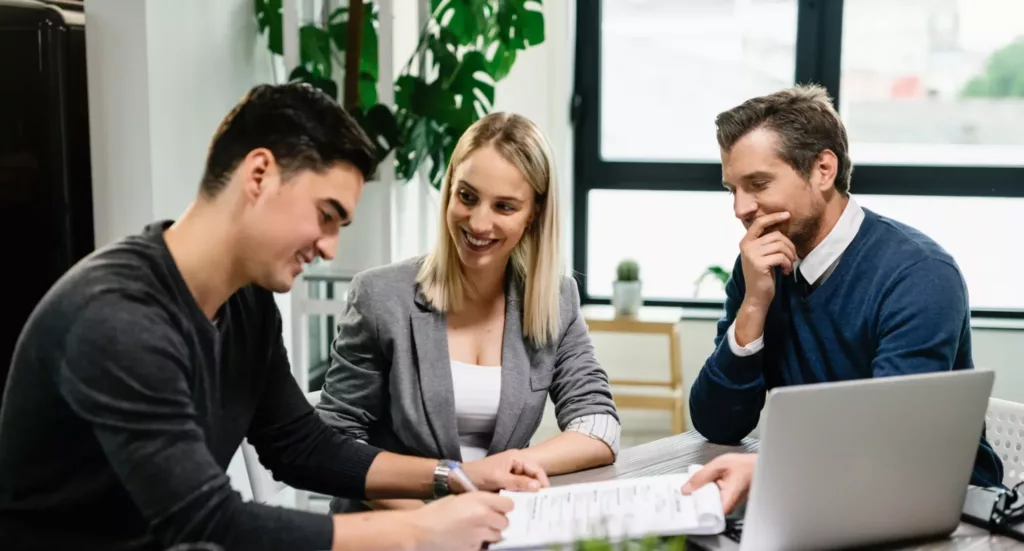 young-happy-couple-signing-agreement-with-real-estate-agent-meeting-office-scaled-e1673450251387-2048×1101